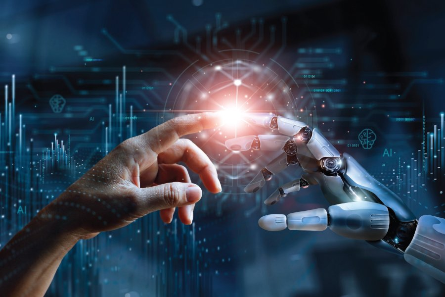 A human hand and a robotic hand reach towards each other, fingertips nearly touching, against a digital background with glowing light and circuit-like patterns.