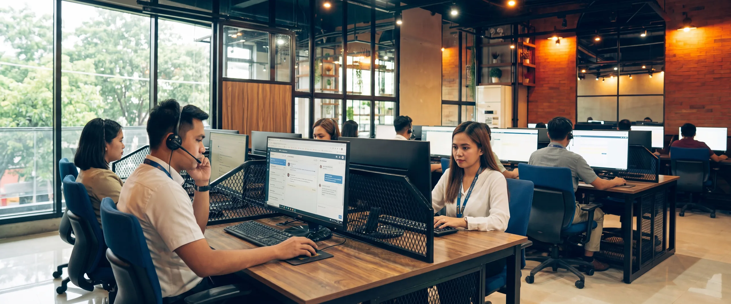 Customer service agents on calls and chat at their desks in a Naga City office