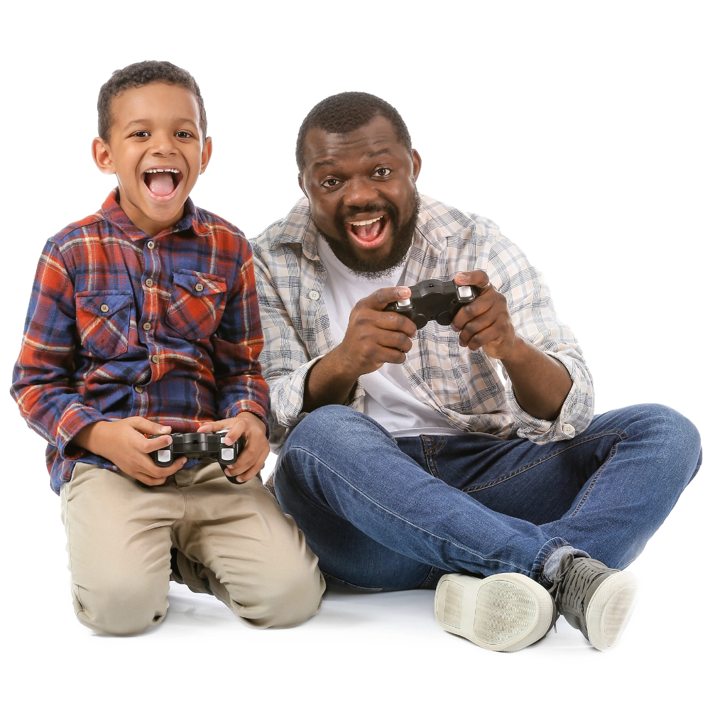 An adult and a child sit on the floor, smiling and holding video game controllers, appearing engaged in playing a game together—just like members of a gaming community moderator team enjoying some friendly competition.